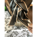 Wrapped bouquet in black paper with blush ribbon in a glass jar