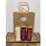 Gift bag with three chocolate bars on a wooden surface