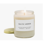 A scented candle in a glass jar with a gold lid