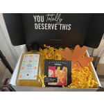 Gift box with shower gel, soap, and an orange flower-shaped item
