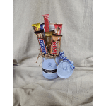 Light blue Hydro Flask mug filled with assorted candy bars and curly ribbon, with matching lid beside it.