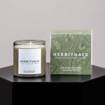 Scented candle in a glass jar beside its green patterned box