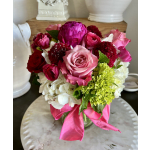 Pink and red mixed flower bouquet in a glass vase with a ribbon