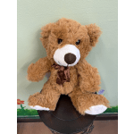 Brown teddy bear with a ribbon bow sitting on a stool