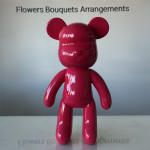 Glossy pink bear figurine standing on a table.