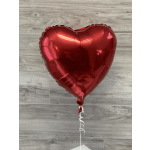 Red heart-shaped foil balloon on a white stick with curling ribbon