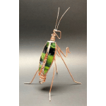 Copper wire insect sculpture with green stained glass body on a dark background