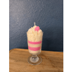 Layered pink and white candle in a glass goblet with a strawberry topper