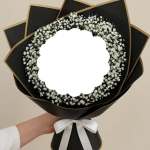 White baby's breath bouquet wrapped in black paper with a white ribbon