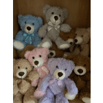 Assorted plush teddy bears in pastel colors with ribbons