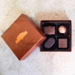 Open box of assorted chocolates with the lid beside it