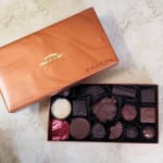 Open box of assorted chocolates with the lid beside it