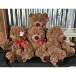 Four brown teddy bears with red ribbons grouped together