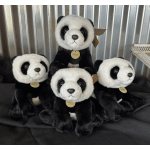 Four plush panda toys arranged together on black fabric