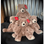 Four plush teddy bears stacked together on a black surface