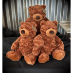 Three brown teddy bears sitting together on black fabric