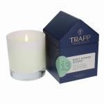 White candle beside a navy fragrance box