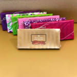 Assorted wrapped chocolate gift boxes stacked on a gold surface