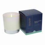 White candle beside a navy gift box