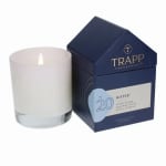 White candle beside a navy fragrance box