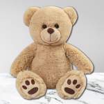 Beige teddy bear plush sitting on a marble surface