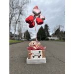 Teddy bear in a gift box with heart balloons and a chocolate box