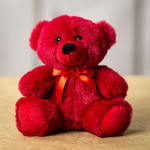 Red teddy bear with an orange ribbon