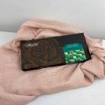 Box of chocolate mint candies on pink fabric