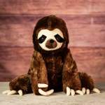 Plush sloth toy sitting upright on a tabletop