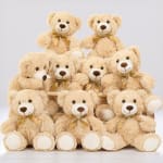 Group of beige teddy bears with gold ribbons arranged in tiers