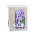 Handmade card with purple floral tag, green leaf cutout, and 'Wishing you all the best' message