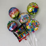 Cluster of colorful birthday balloons on white sticks