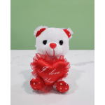 White teddy bear holding a red heart pillow