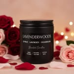 Black scented candle jar surrounded by roses and petals