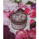 Scented candle in a tin surrounded by pink and purple flowers