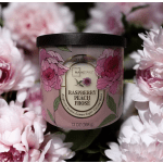 Pink floral-scented candle in a black-lidded jar surrounded by pink flowers