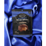 Bag of milk chocolate sea salt caramels on blue satin fabric