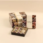 Boxes of assorted chocolate truffles on a beige background