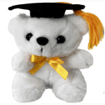 White plush teddy bear wearing a black graduation cap with yellow tassel and bow