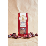 Box of berry chocolate hearts with pieces scattered around it