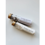 Two botanical milk bath tubes with gold caps on a white surface