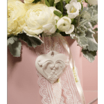 Cream-colored flower arrangement with a lace ribbon and heart ornament