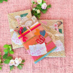 Three decorated blind date books with small floral accents on pink fabric.