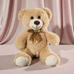 Plush teddy bear with a satin bow sitting against pink drapery