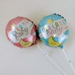Two baby shower balloons reading "Welcome baby" in pink and blue