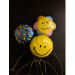 Three smiley-face balloons against a dark wall