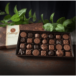 Box of assorted chocolates with green leaves behind it