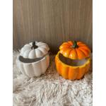 Two pumpkin-shaped ceramic containers with lids, one white and one orange
