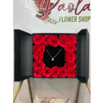 Box of red roses with a small heart necklace in the center
