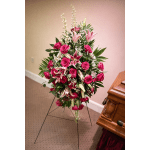 Standing floral spray with pink roses and lilies on a black easel